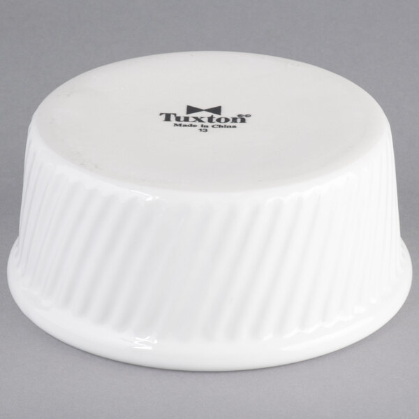 A white Tuxton china souffle/ramekin with a swirl design on the sides.