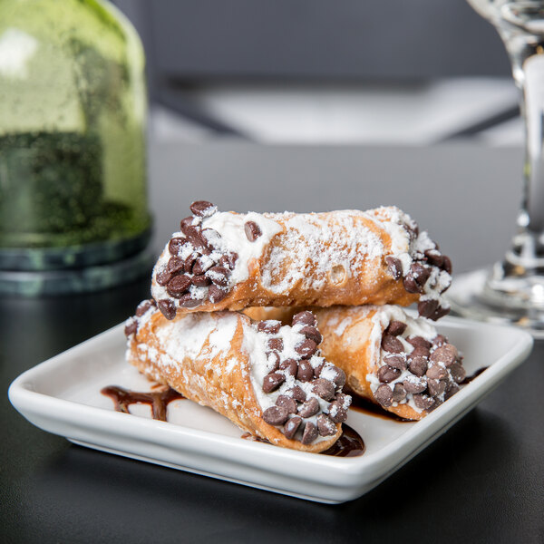 A Tuxton porcelain white square tray with three chocolate-covered pastries.