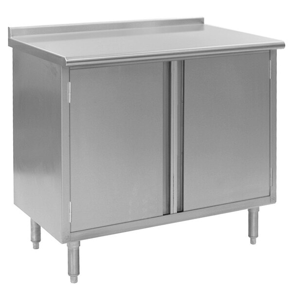 A stainless steel cabinet with two doors on a metal work table.