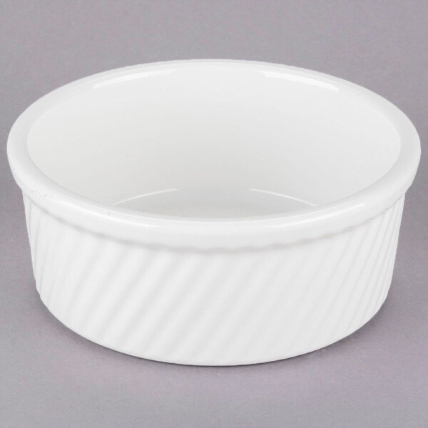 A white Tuxton souffle bowl on a gray surface.
