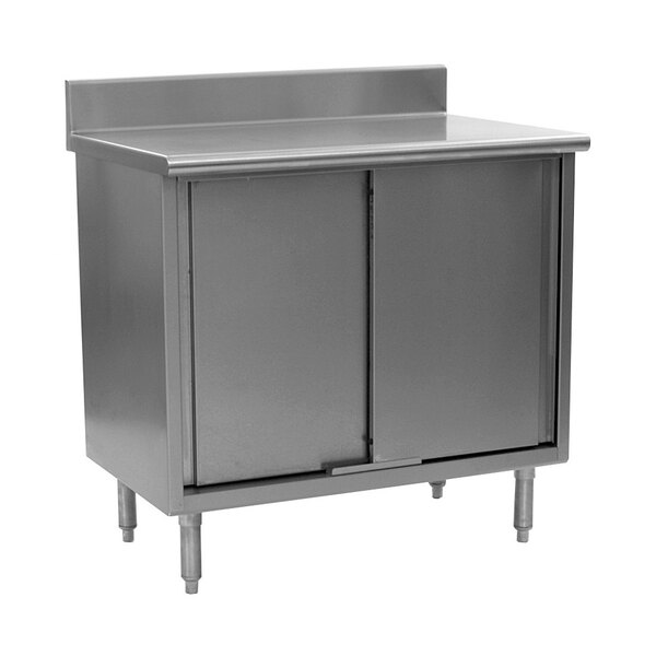 A stainless steel cabinet with a door on a steel work table.