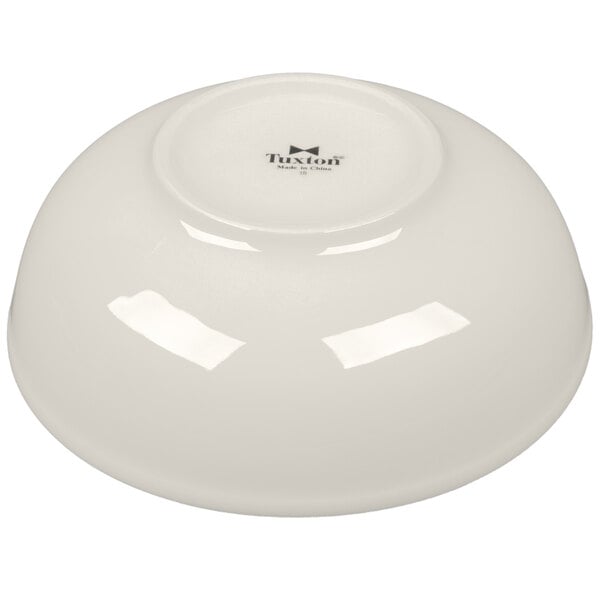 A white Tuxton china bowl with black text.