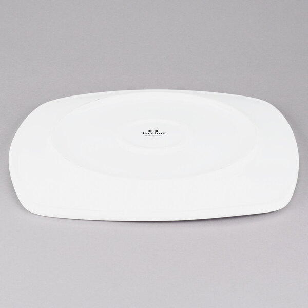 A Tuxton white square china plate with a small hole in the middle.