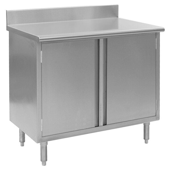 A stainless steel Eagle Group work table with a cabinet base and two doors.