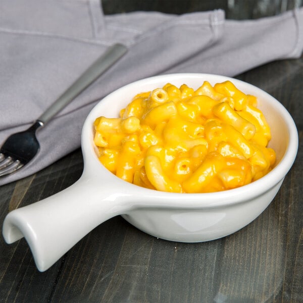A Tuxton eggshell china bowl filled with macaroni and cheese with a fork.