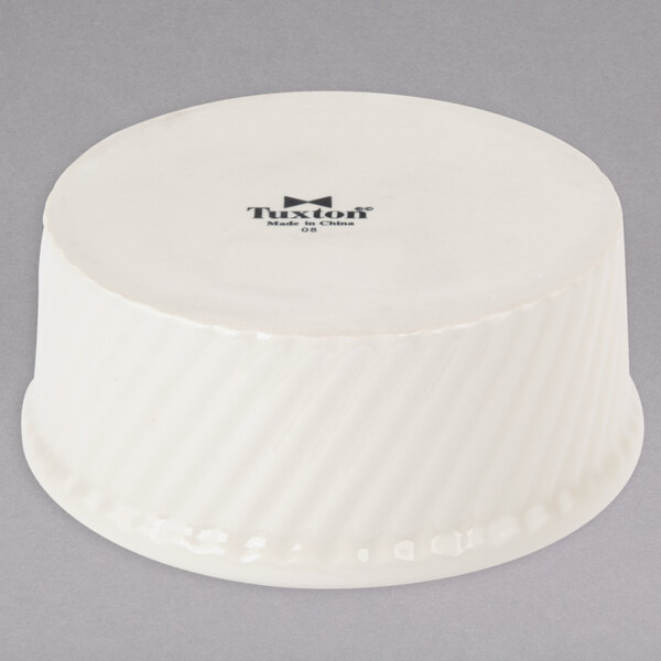 A white Tuxton ramekin with a black swirl pattern.