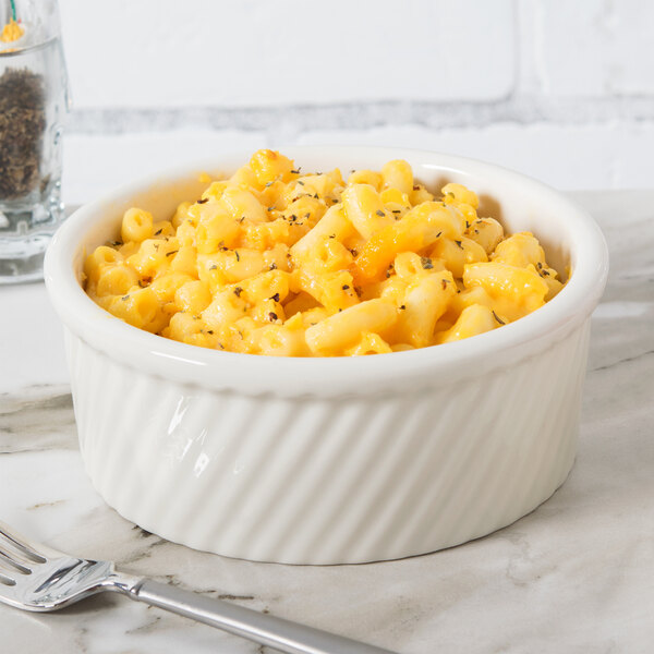 A white Tuxton Eggshell Swirl ramekin filled with macaroni and cheese.