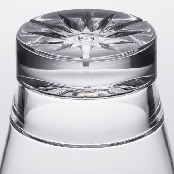 A close up of a Thunder Group clear plastic starburst rocks glass on a table.