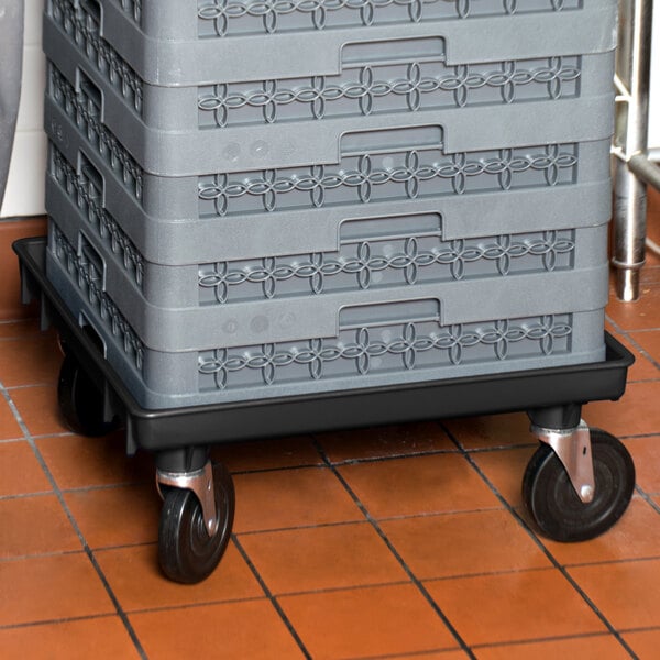 A black Vollrath Traex rack dolly base for plastic crates.