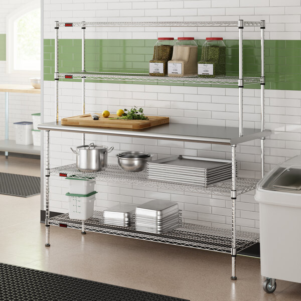A stainless steel table with two chrome wire undershelves and two chrome wire overshelves, used for kitchen storage and prep.