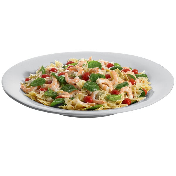 A Tablecraft cast aluminum platter with a plate of pasta with shrimp, spinach, and tomatoes.