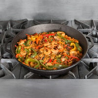 Cast iron skillet on stovetop, filled with stir-fry