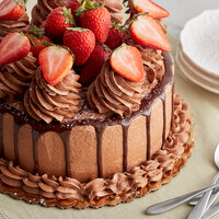 Chocolate cake with chocolate frosting, ganache drizzles, and strawberries made with vegan baking ingredients.