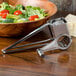 A bowl of salad with tomatoes and broccoli next to an American Metalcraft stainless steel cheese grater.