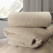 A stack of Oxford beige herringbone hotel blankets.