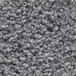A close-up of a grey rubber-backed carpet with small spots.