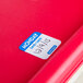 A red National Checking Company Monday food labeling sticker on a red surface.