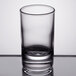 An Arcoroc clear glass shot glass on a table.