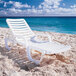 A white plastic Grosfillex Bahia chaise lounge on a beach.