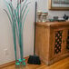 A Carlisle warehouse broom with black bristles leaning against a cabinet.