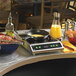 A Vollrath countertop induction range with food cooking in a pan.