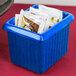 A blue Tablecraft rectangle server with tea packets inside on a hotel buffet counter.