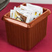 A Tablecraft copper cast aluminum rectangle server with tea packets in it on a hotel buffet counter.