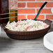 A Tablecraft Midnight Speckle shallow oval casserole dish filled with food on a table.