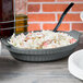 A Tablecraft granite shallow oval casserole dish filled with food on a table.