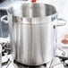 A large Vollrath stainless steel stock pot on a stove.