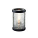 A Sterno clear glass candle holder with bronze accent rings holding a lit candle.
