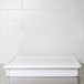 An American Metalcraft white ABS plastic cover for a standard dough box on a stainless steel counter.
