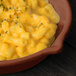 A Tablecraft copper cast aluminum fry pan filled with macaroni and cheese on a table.