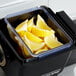 A San Jamar dome replacement tray filled with lemon wedges on a counter.