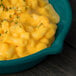 A bowl of macaroni and cheese in a Tablecraft hunter green cast aluminum fry pan.