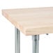 An Advance Tabco wood top work table with a galvanized metal base.