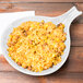 A Tablecraft white cast aluminum skillet with rice and beans on top.