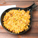 A Tablecraft black cast aluminum skillet with rice and beans on it.