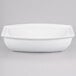 A white rectangular Tablecraft salad bowl with curved edges.