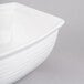 A white Tablecraft cast aluminum bowl with handles.