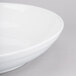 A close-up of a Tablecraft white cast aluminum pasta bowl with a rim.