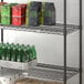 A Regency black epoxy wire shelf with drinks and boxes on it.