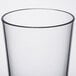 A clear plastic mixing glass with a black rim.