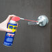 A person using WD-40 Smart Straw to lubricate a door hinge.