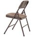 A brown National Public Seating metal folding chair with a russet walnut fabric padded seat.