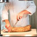 A chef using an Alto-Shaam carving station to cut meat.