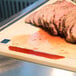 A carving station with sliced meat on a cutting board.