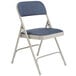 A gray metal National Public Seating folding chair with a blue fabric cushion.