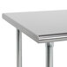 An Advance Tabco stainless steel work table with an open metal base.