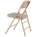 A National Public Seating beige metal folding chair with a cafe beige padded seat.